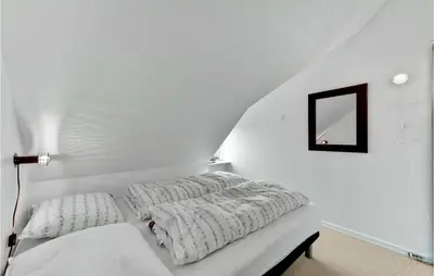 a white room with a bed and a mirror at Gorgeous Apartment In Lemvig in Lemvig