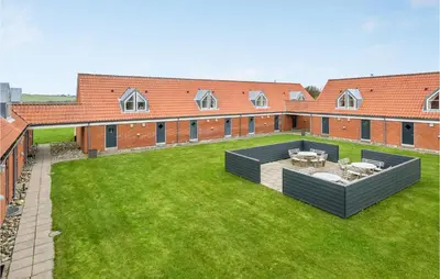 a courtyard with a building and a lawn with tables at Gorgeous Apartment In Lemvig in Lemvig