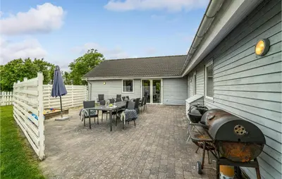 a patio with a grill and a table and chairs at 7 Bedroom Gorgeous Home In Vinderup in Vinderup
