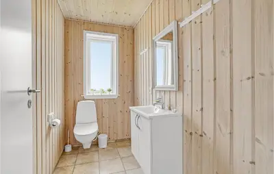 a bathroom with a toilet and a sink and a window at 7 Bedroom Gorgeous Home In Vinderup in Vinderup