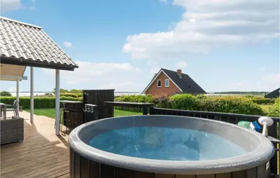 a hot tub on the deck of a house at Awesome Home In Øster Assels With Sauna in Øster Assels