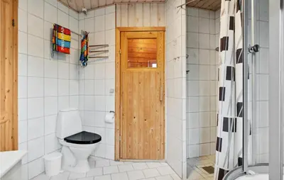 a bathroom with a toilet and a wooden door at Lovely Home In Fjerritslev With Wifi in Fjerritslev