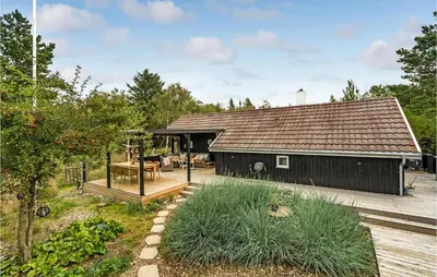 a black barn with a deck and a house at 3 Bedroom Nice Home In Hurup Thy in Sønder Ydby