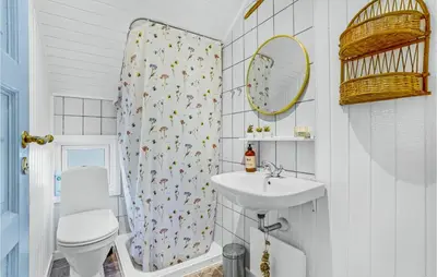 a bathroom with a sink and a toilet and a mirror at 3 Bedroom Nice Home In Hurup Thy in Sønder Ydby