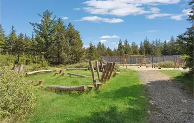 a park with a playground with logs in the grass at 4 Bedroom Lovely Home In Fjerritslev in Fjerritslev