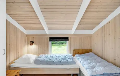 a bedroom with a large bed in a wooden ceiling at 3 Bedroom Beautiful Home In Frøstrup in Frøstrup