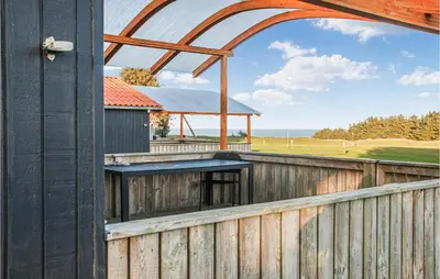 an external view of a wooden fence with an archway at Lovely Home In Hanstholm With Wifi in Hanstholm