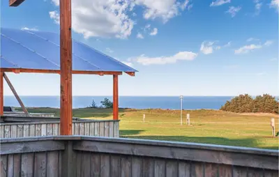a view of a field with the ocean in the background at Lovely Home In Hanstholm With Wifi in Hanstholm