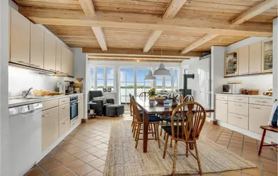 a kitchen with a table and chairs and a dining room at Beautiful Home In Frøstrup With Sauna in Frøstrup
