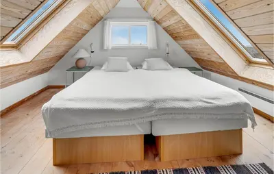 a bedroom with a large bed in a attic at Beautiful Home In Frøstrup With Sauna in Frøstrup
