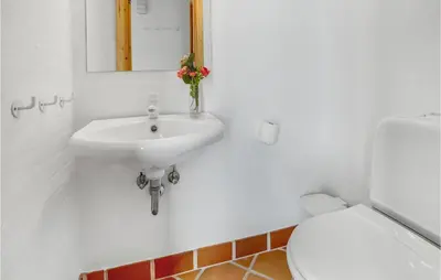 a white bathroom with a sink and a toilet at Beautiful Home In Frøstrup With Sauna in Frøstrup