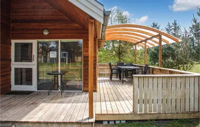 a wooden deck with a table and chairs on it at Stunning Home In Hanstholm With Wifi in Hanstholm