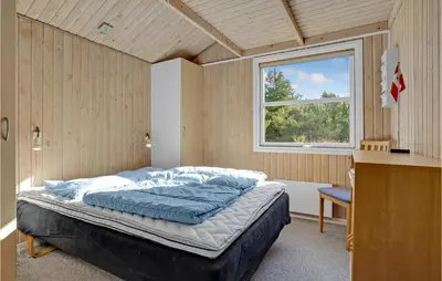 a bedroom with a bed in a room with a window at Stunning Home In Fjerritslev With Sauna in Fjerritslev