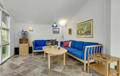 a living room with a blue couch and a table at Stunning Home In Fjerritslev With Sauna in Fjerritslev