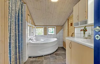 a bathroom with a tub and a sink at Stunning Home In Fjerritslev With Sauna in Fjerritslev