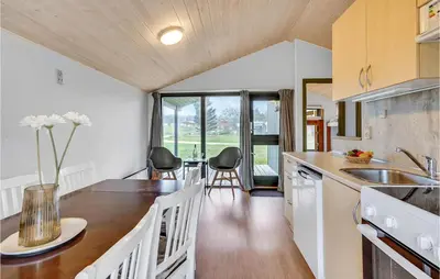 a kitchen with a table and chairs in a room at Cozy Home In Hanstholm With Kitchen in Hanstholm
