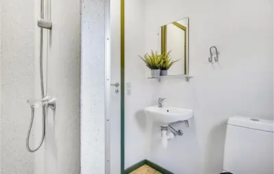 a bathroom with a sink and a mirror at Cozy Home In Hanstholm With Kitchen in Hanstholm