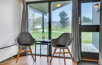 two chairs and a table in front of a window at Cozy Home In Hanstholm With Kitchen in Hanstholm