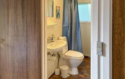 a bathroom with a toilet and a sink at 2 Bedroom Nice Home In Fjerritslev in Fjerritslev