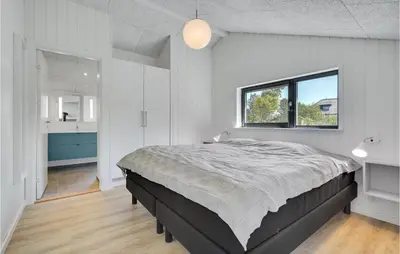 a bedroom with a large bed and a window at Nice Home In Blokhus With Wifi in Blokhus
