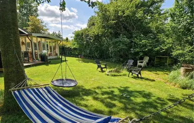 a hammock in a yard next to a house at 2 Bedroom Awesome Home In Farsø in Farsø