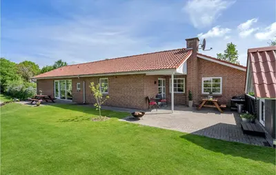 a brick house with a patio and a yard at Pet Friendly Home In Farsø With Sauna in Farsø