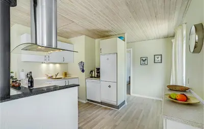 a kitchen with white appliances and a wooden ceiling at Cozy Home In Farsø With Sauna in Farsø
