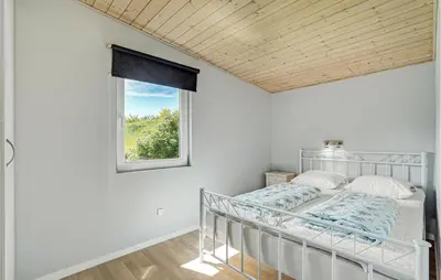 a bedroom with a bed and a window at Cozy Home In Farsø With Sauna in Farsø