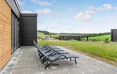 a group of benches sitting on a patio at 4 Bedroom Awesome Home In Løgstrup in Løgstrup