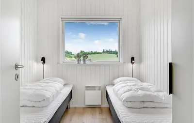 three beds in a room with a window at 4 Bedroom Awesome Home In Løgstrup in Løgstrup
