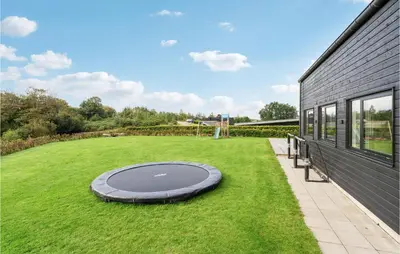 a large yard with a trampoline in the grass at Lovely Home In Løgstrup With Wifi in Løgstrup