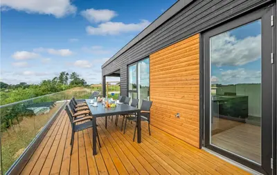 a wooden deck with a table and chairs on it at Beautiful Home In Løgstrup With Kitchen in Løgstrup