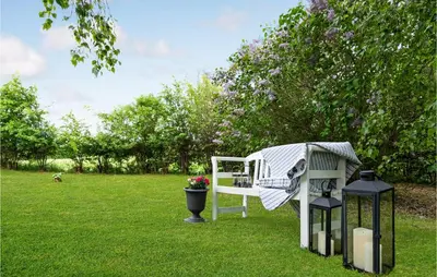 a white bench sitting in the grass with a blanket on it at Beautiful Home In Løgstrup With Wifi in Løgstrup