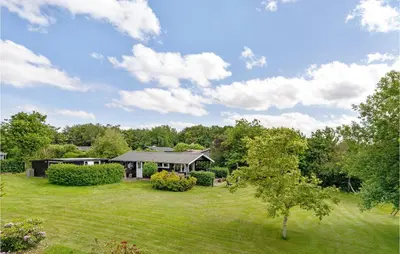 a house in a field with a grass yard at Gorgeous Home In Farsø With Kitchen in Farsø