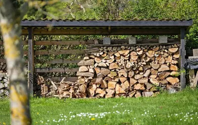a pile of fire wood next to a fence at Gorgeous Home In Farsø With Kitchen in Farsø