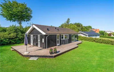 a small house on a wooden deck in a yard at Cozy Home In Løgstrup With Kitchen in Løgstrup