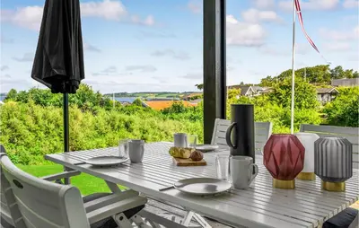 a wooden table with a plate of food on it at Cozy Home In Løgstrup With Kitchen in Løgstrup