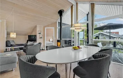 a dining room with a white table and chairs at Cozy Home In Løgstrup With Kitchen in Løgstrup