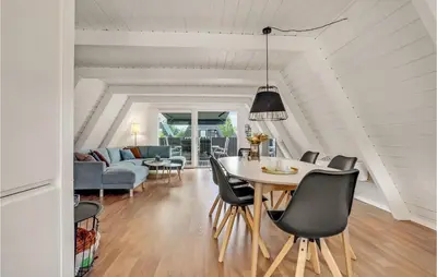 a dining room and living room with a table and chairs at 2 Bedroom Cozy Home In Farsø in Farsø