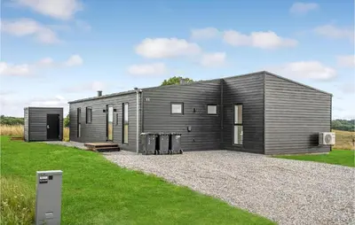 a small black house with a gravel driveway at 4 Bedroom Gorgeous Home In Løgstrup in Løgstrup
