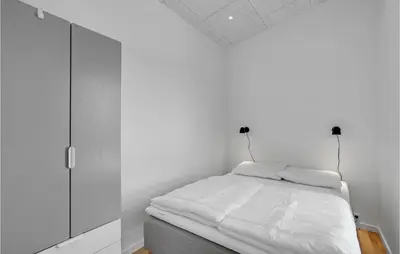 a white bedroom with a bed and a cabinet at 4 Bedroom Gorgeous Home In Løgstrup in Løgstrup
