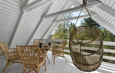a porch with a wooden table and chairs at 3 Bedroom Cozy Home In Højslev in Højslev