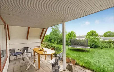 a patio with a table and chairs and a swing at Nice Home In Løgstrup With Wifi in Løgstrup