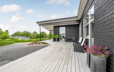 a wooden deck on the side of a house at Cozy Home In Farsø With Wifi in Farsø