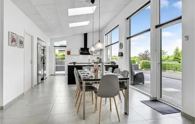 a dining room and kitchen with a table and chairs at Cozy Home In Farsø With Wifi in Farsø