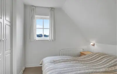 a white bedroom with a bed and a window at Amazing Home In Blokhus With Wifi in Blokhus