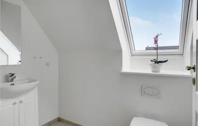 a bathroom with a window and a toilet and a sink at Amazing Home In Blokhus With Wifi in Blokhus
