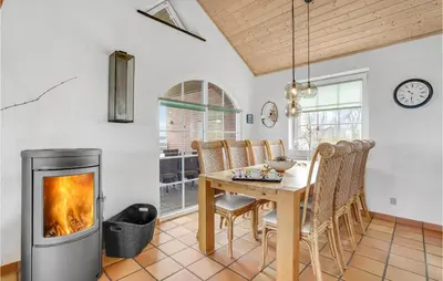 a living room with a fireplace and a table at Awesome Home In Lemvig With Kitchen in Lemvig