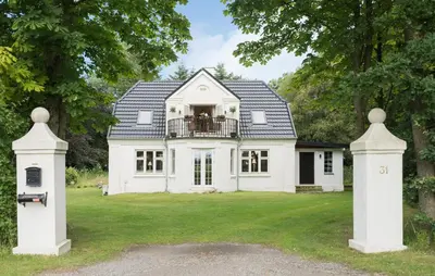 a white house with a gate in the yard at Pet Friendly Home In Roslev With Wifi in Roslev