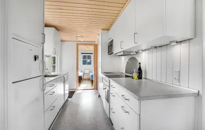 a kitchen with white cabinets and a wooden ceiling at Beautiful Home In Vinderup With Kitchen in Vinderup